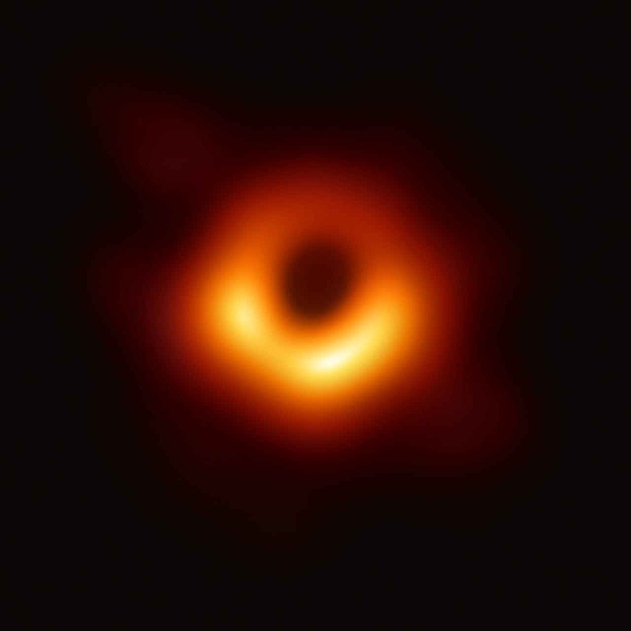 The Event Horizon Telescope’s 2019 image of M87*: a bright, slightly asymmetric orange ring of light around a dark central shadow.